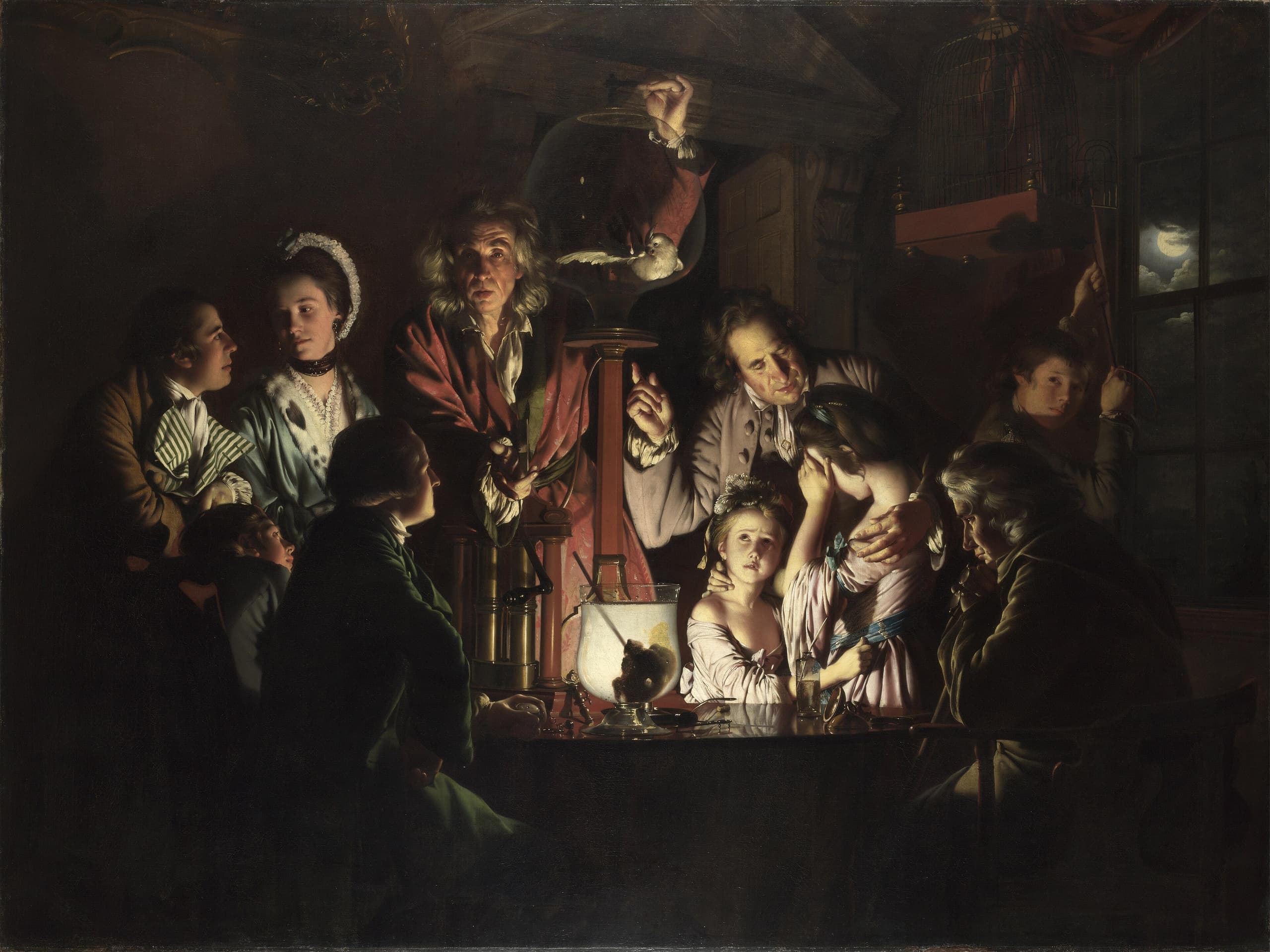 A darkened interior lit by a strong central light. A man stands over a glass air pump containing a pale bird, surrounded by men, women and children whose faces show curiosity, distress and attention.