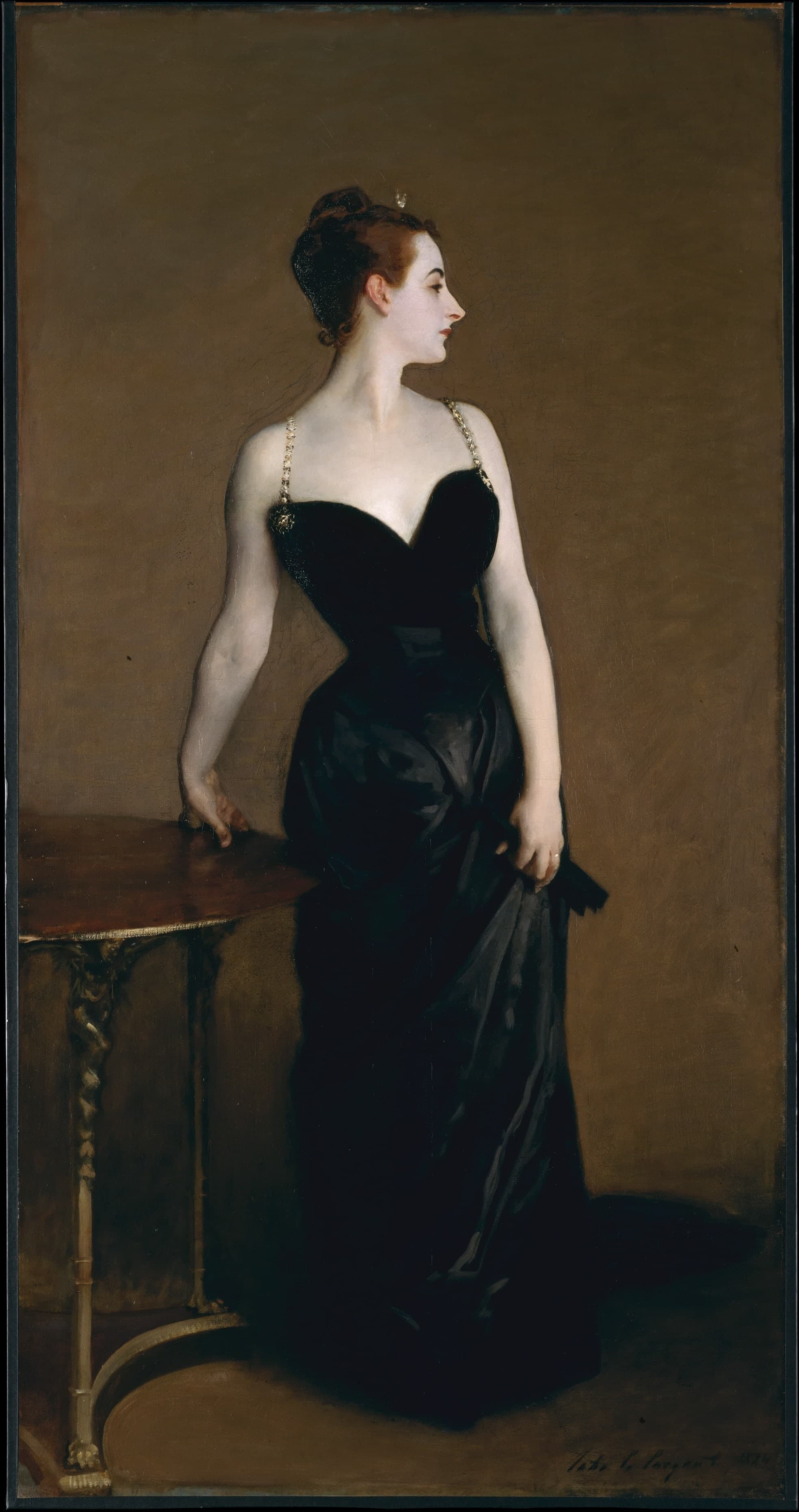 A woman in strict profile stands against a dark background, wearing a long black satin gown with jewelled straps. Her skin is very pale, her right hand rests on her hip, and her left hand holds a fan.
