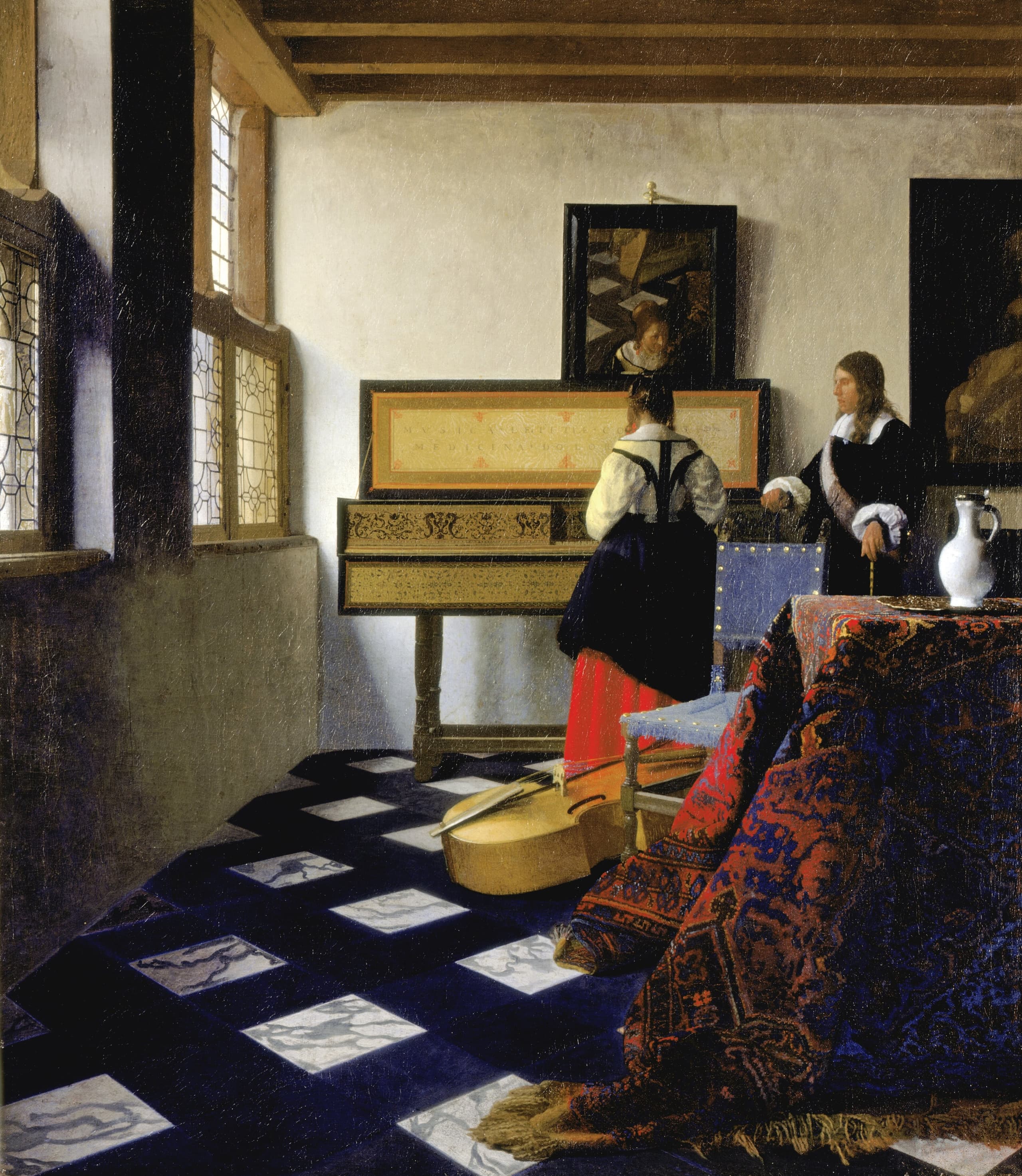 A sunlit room with a tiled floor. A young woman sits at a virginal; a man stands beside her. A draped rug and a white jug occupy the foreground; daylight falls from the windows.