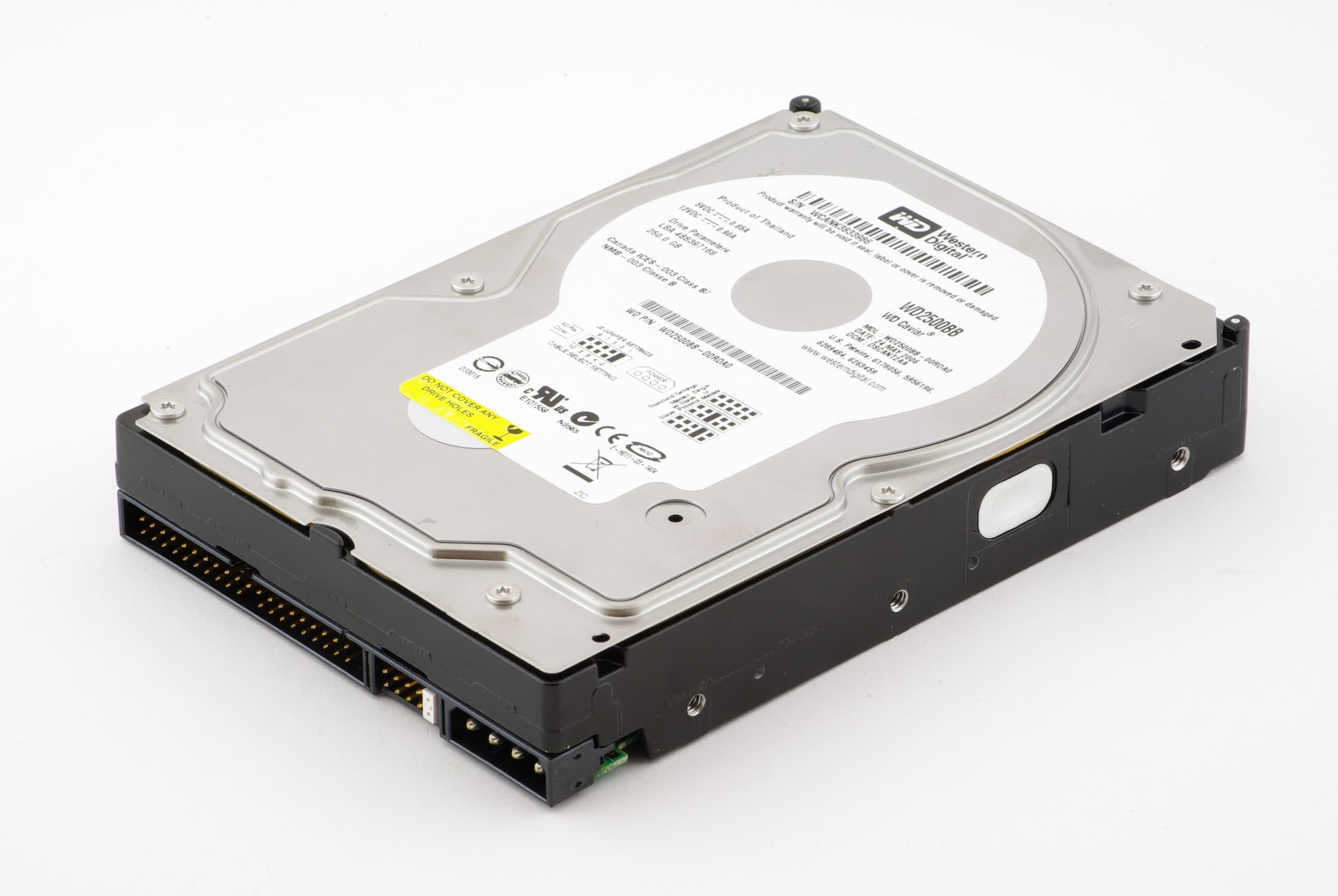 A rectangular metal box with a visible top cover, showing the internal mechanism of a hard disk drive with circular platters and a moving actuator arm holding the read-write heads.