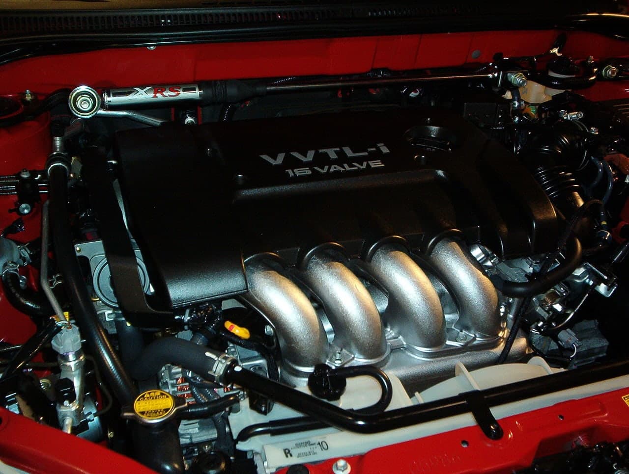 A cutaway diagram of a piston engine, showing the combustion chamber, piston, connecting rod, and crankshaft, with arrows indicating the direction of force from expanding gases.