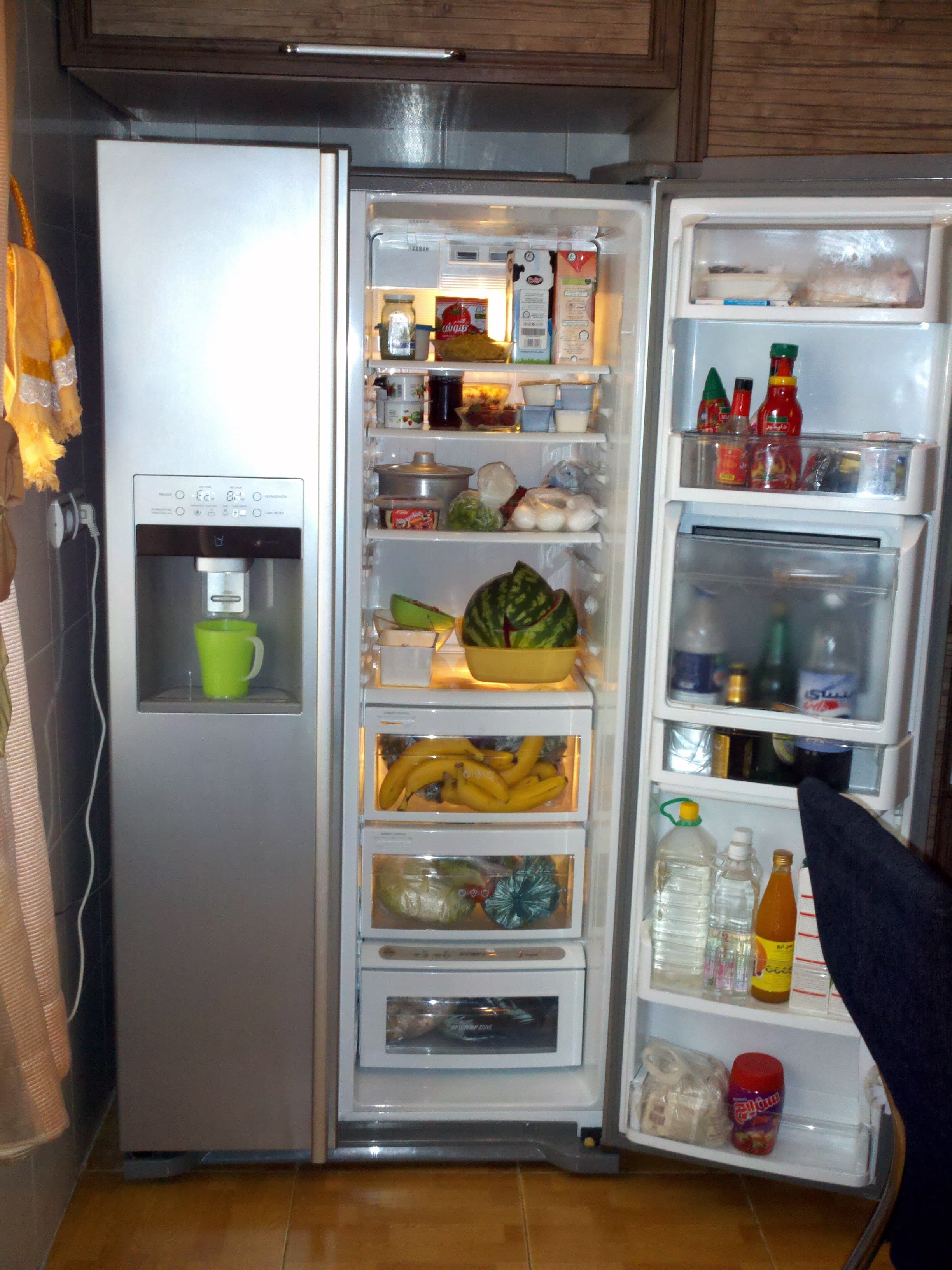 A tall white domestic refrigerator with two doors, the upper section smaller than the lower, standing against a plain background.