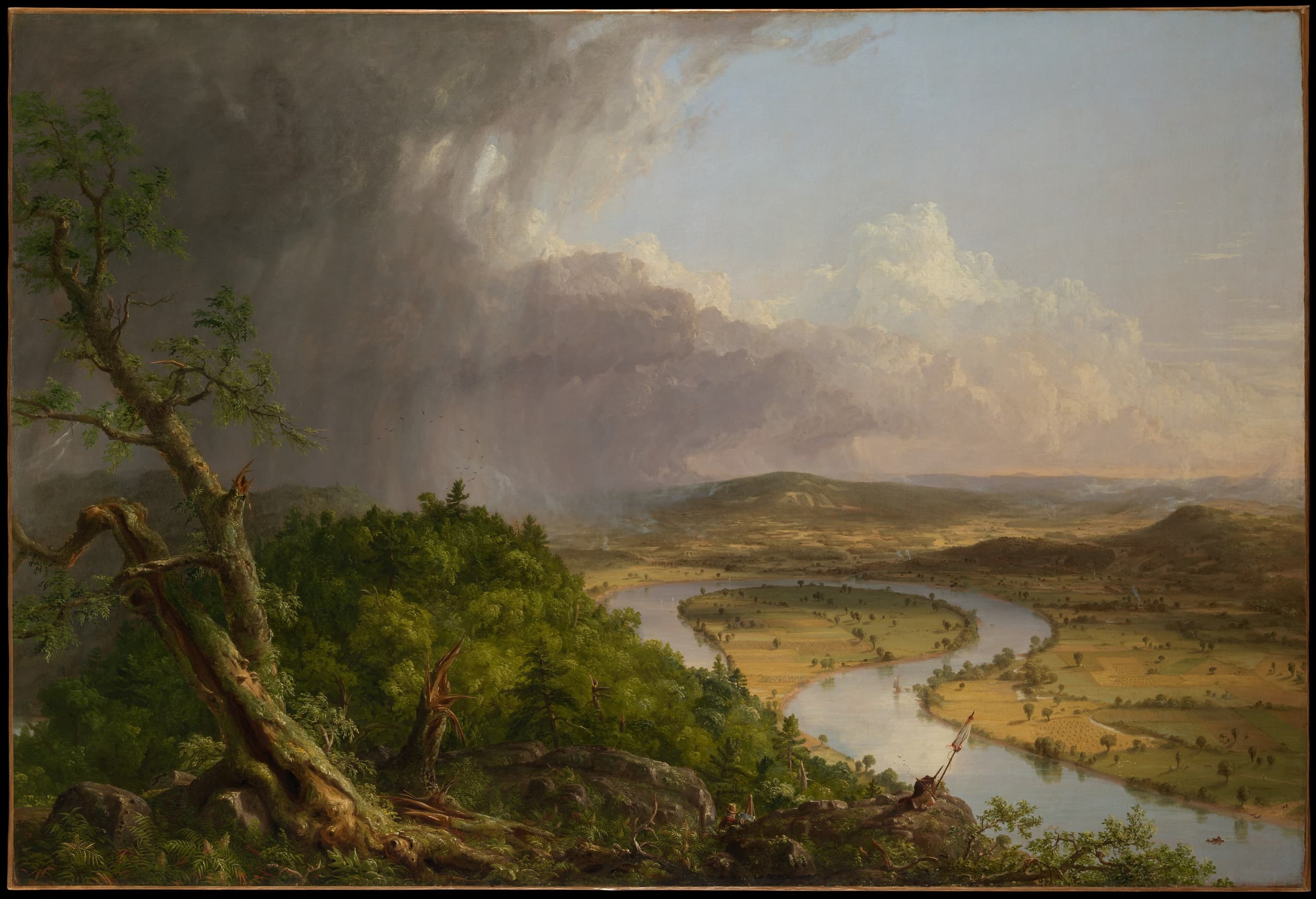 A wide landscape view after a storm, with a river making a large bend through a broad valley beneath a changing sky.