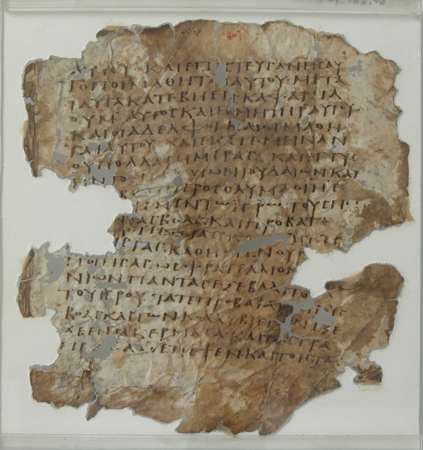 A single leaf of vellum with Greek text in uncial script, dark ink on pale parchment, with rounded capital letters arranged in neat columns.