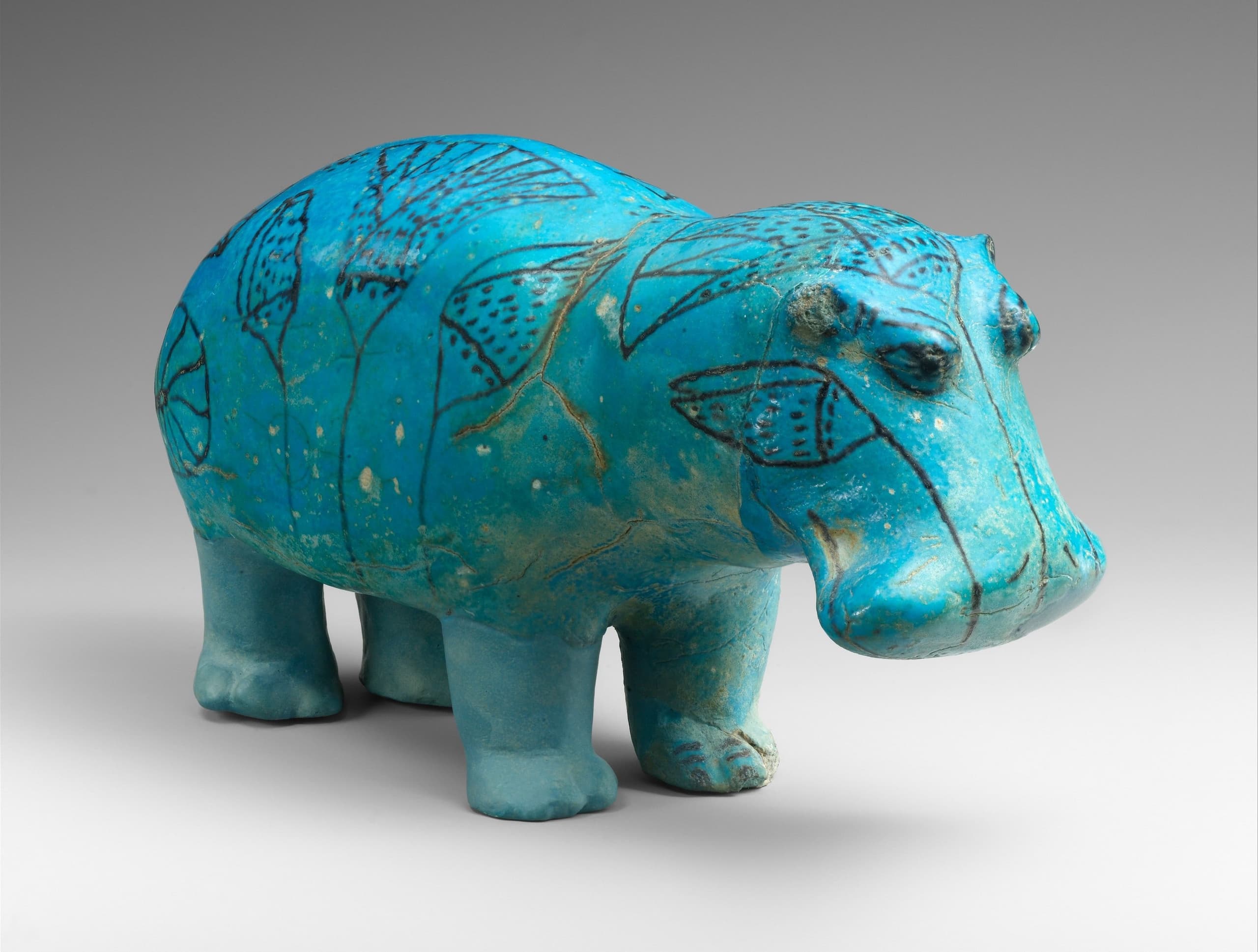A small standing hippopotamus figurine in glazed Egyptian faience, compact and fully modelled, shown as a solid four-legged animal without a base plaque.