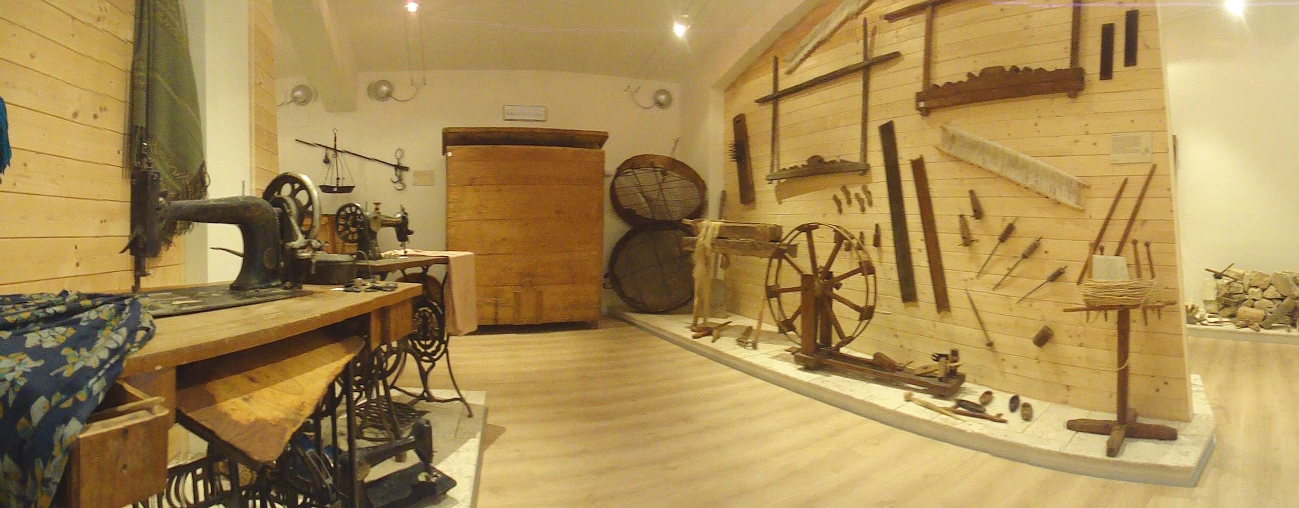 A steel sewing machine with a hand-turned flywheel, a needle arm, and a flat surface for holding fabric, showing the mechanical components that automate stitching.