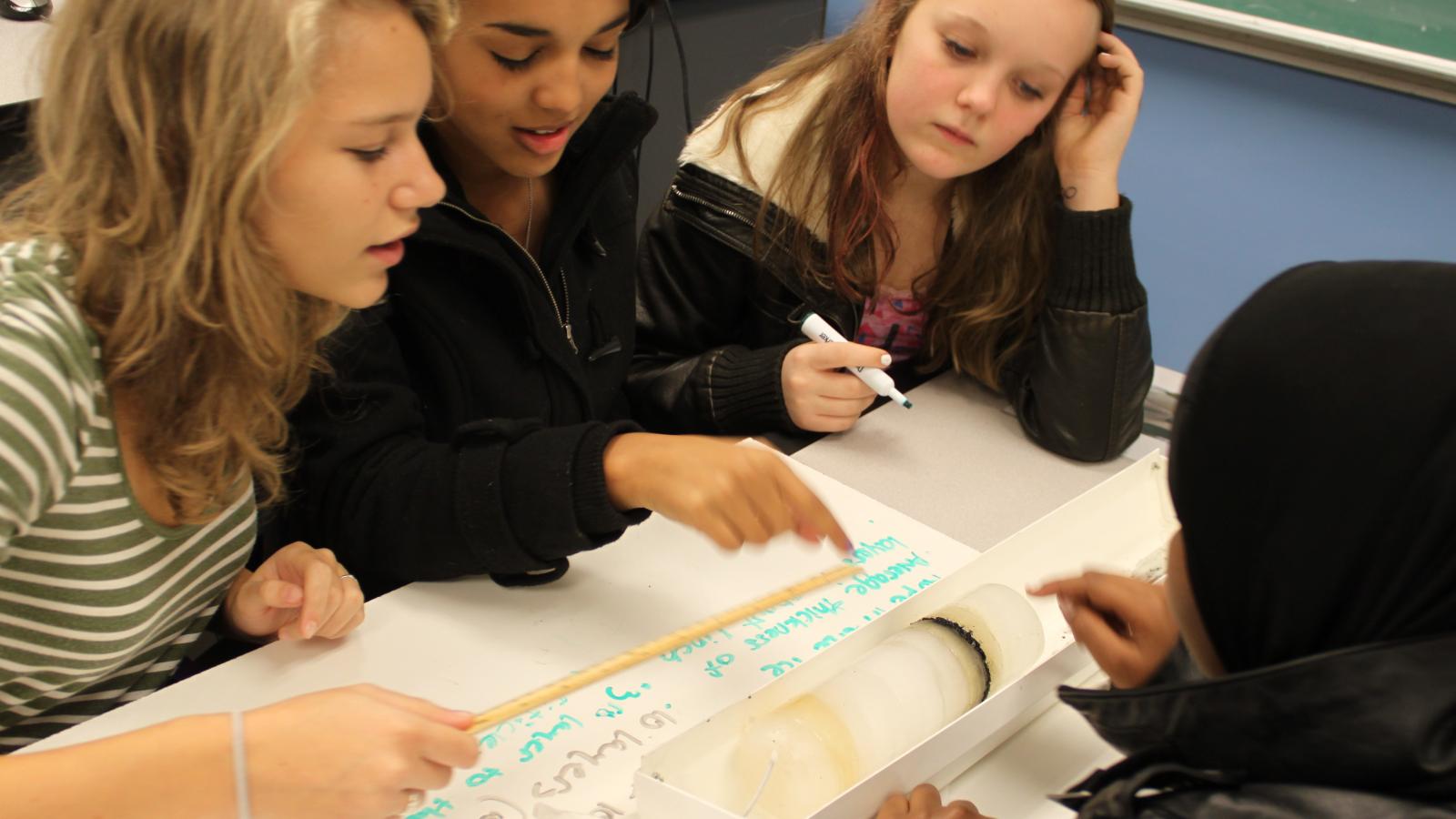 Students examining an ice core sample in a classroom setting